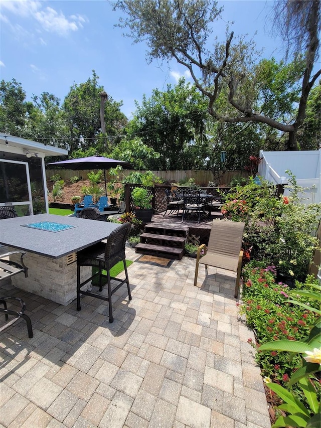 fenced backyard with a patio, a deck, and outdoor dining space