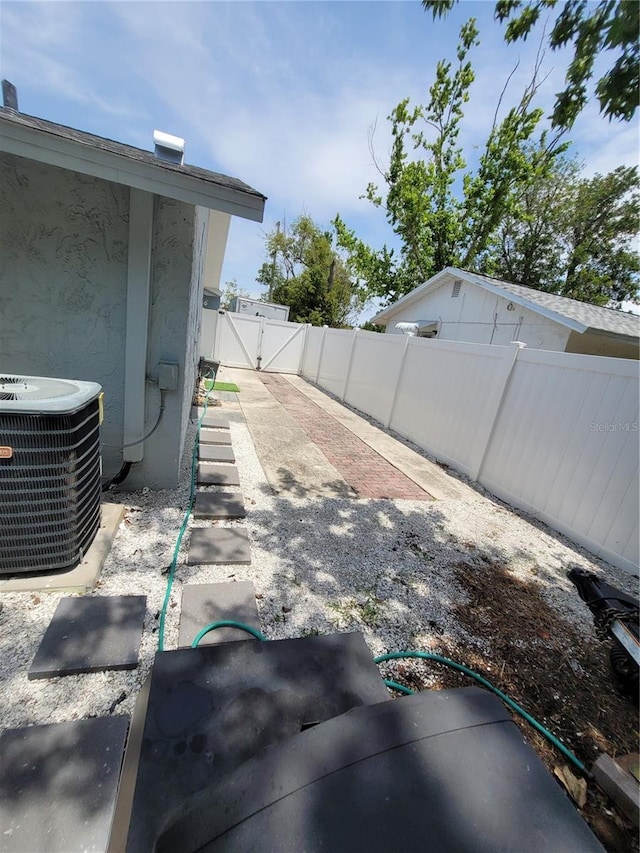 view of yard with central air condition unit and a gate