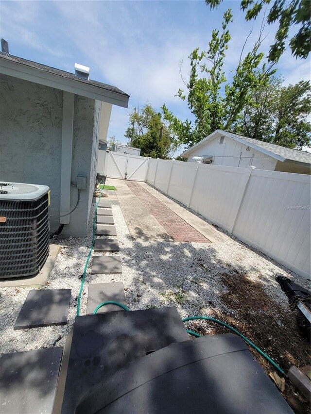 view of yard with central air condition unit and a gate