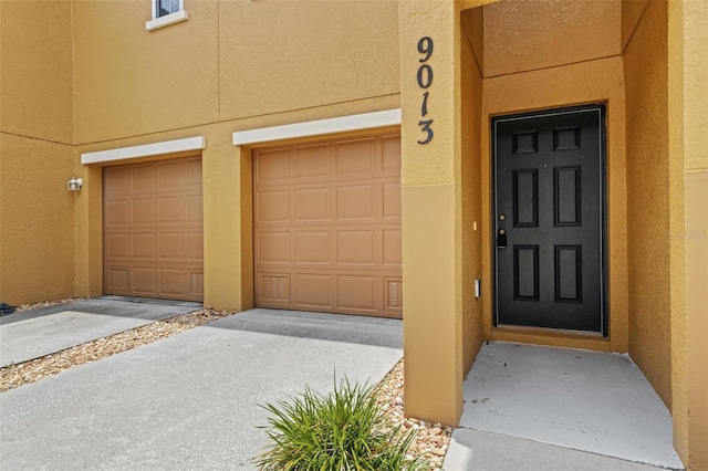 9013 White Sage Loop, Lakewood Ranch, FL 34202 - doorway to property with stucco siding and an attached garage