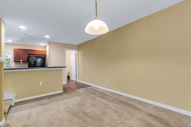 9013 White Sage Loop, Lakewood Ranch, FL 34202 - kitchen with freestanding refrigerator, dark countertops, baseboards, light colored carpet, and recessed lighting