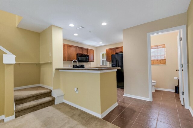 9013 White Sage Loop, Lakewood Ranch, FL 34202 - kitchen featuring black appliances, brown cabinetry, a peninsula, healthy amount of natural light, and recessed lighting