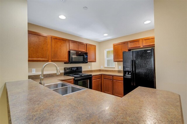 9013 White Sage Loop, Lakewood Ranch, FL 34202 - kitchen with black appliances, a sink, brown cabinetry, recessed lighting, and a peninsula