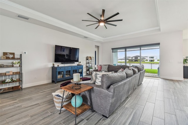8192 Ivy Stark Blvd, Wesley Chapel, FL 33545 - living area with a tray ceiling, light wood-style flooring, ceiling fan, baseboards, and crown molding