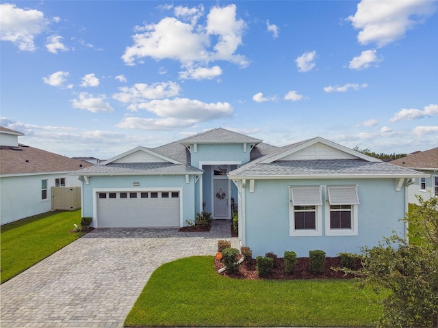 8192 Ivy Stark Blvd, Wesley Chapel, FL 33545 - view of front of home with an attached garage, a front yard, stucco siding, decorative driveway, and roof with shingles