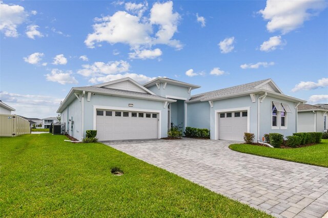 8192 Ivy Stark Blvd, Wesley Chapel, FL 33545 - ranch-style home featuring an attached garage, a front lawn, central AC unit, and stucco siding