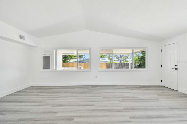 695 Sunset Dr, Tarpon Springs, FL 34689 - spare room with lofted ceiling, healthy amount of natural light, light wood-style flooring, and baseboards