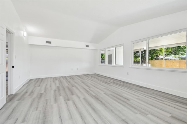 695 Sunset Dr, Tarpon Springs, FL 34689 - spare room with lofted ceiling, healthy amount of natural light, light wood-style flooring, and baseboards