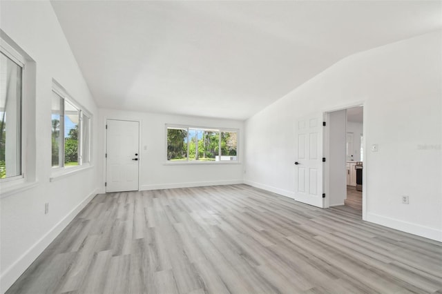 695 Sunset Dr, Tarpon Springs, FL 34689 - unfurnished living room with lofted ceiling, light wood-type flooring, and baseboards