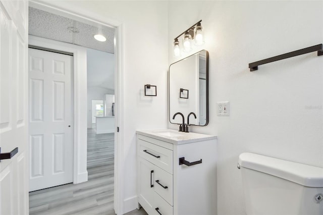 695 Sunset Dr, Tarpon Springs, FL 34689 - half bath featuring wood finished floors, toilet, vanity, and baseboards