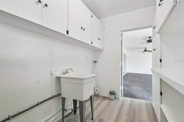 695 Sunset Dr, Tarpon Springs, FL 34689 - laundry room with cabinet space, a ceiling fan, and light wood-type flooring