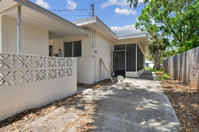 695 Sunset Dr, Tarpon Springs, FL 34689 - view of side of home featuring a sunroom and a patio