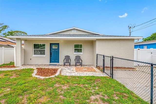 3927 Spence Ave, Tampa, FL 33614 - view of front facade with stucco siding, a patio area, and a gate