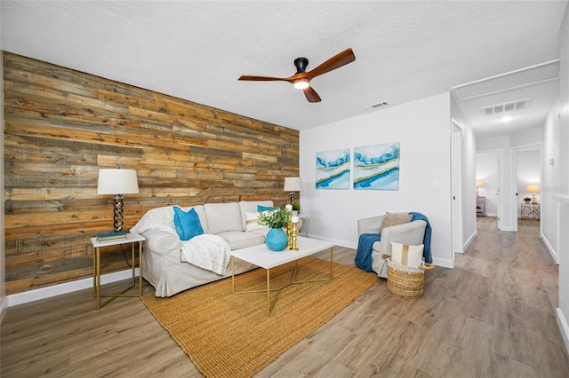 3927 Spence Ave, Tampa, FL 33614 - living room featuring attic access, ceiling fan, wooden walls, wood finished floors, and baseboards