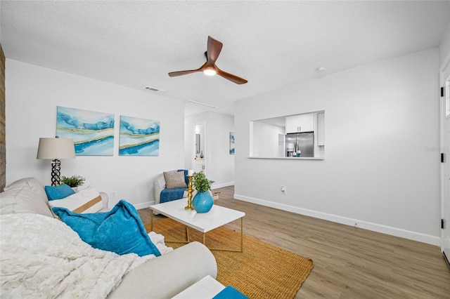 3927 Spence Ave, Tampa, FL 33614 - living room featuring wood finished floors, ceiling fan, baseboards, and attic access