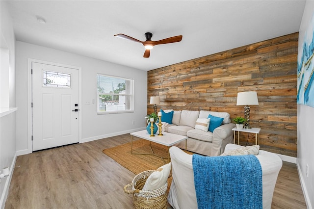 3927 Spence Ave, Tampa, FL 33614 - living area featuring a ceiling fan, wooden walls, wood finished floors, and baseboards