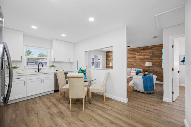 3927 Spence Ave, Tampa, FL 33614 - dining space featuring baseboards, light wood-style flooring, recessed lighting, and wood walls