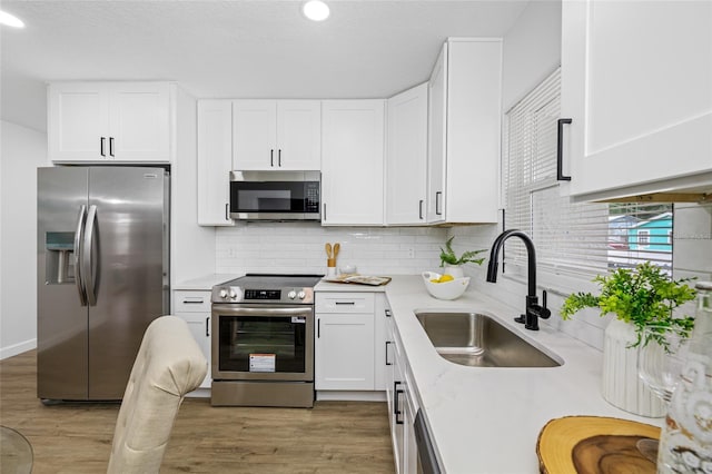 3927 Spence Ave, Tampa, FL 33614 - kitchen with stainless steel appliances, a sink, light countertops, decorative backsplash, and white cabinetry