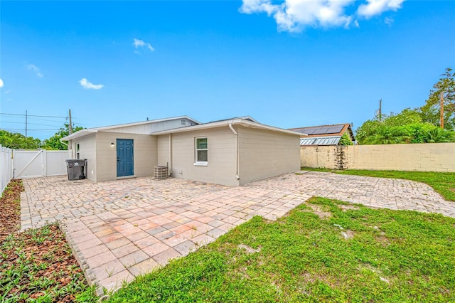 3927 Spence Ave, Tampa, FL 33614 - rear view of property with a gate, a patio area, a fenced backyard, central air condition unit, and concrete block siding
