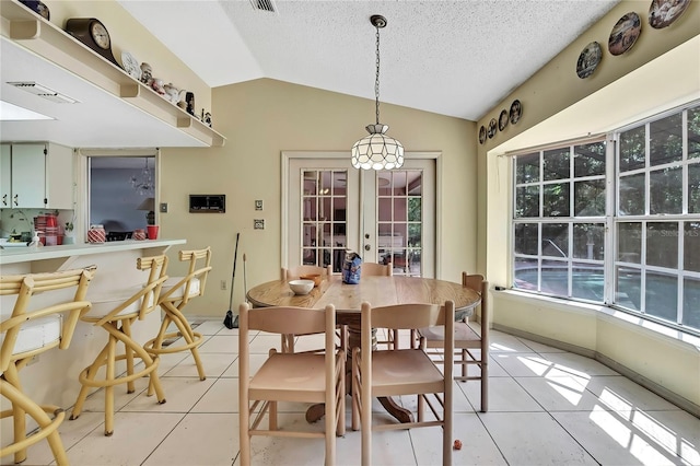 4388 Tiffin Ave, Spring Hill, FL 34609 - dining space with light tile patterned floors, vaulted ceiling, french doors, and a textured ceiling