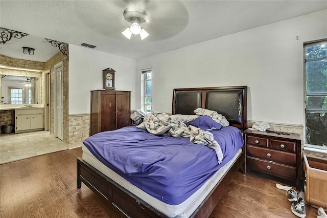 4388 Tiffin Ave, Spring Hill, FL 34609 - bedroom with a wainscoted wall, multiple windows, wood finished floors, a sink, and ceiling fan