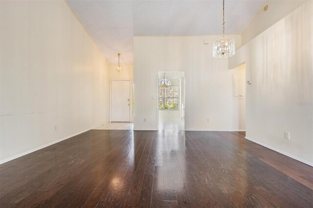 2355 Bentley Dr, Palm Harbor, FL 34684 - empty room with a chandelier, wood-type flooring, baseboards, and a high ceiling