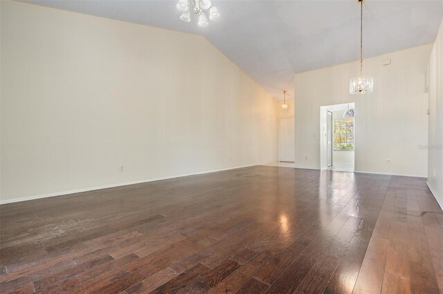2355 Bentley Dr, Palm Harbor, FL 34684 - spare room with a chandelier, wood-type flooring, high vaulted ceiling, and baseboards