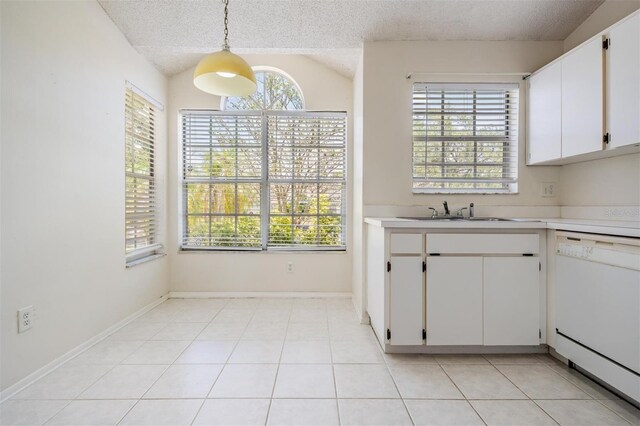 2355 Bentley Dr, Palm Harbor, FL 34684 - kitchen featuring white dishwasher, a sink, light countertops, lofted ceiling, and white cabinets