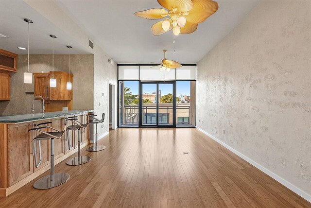 400 4th Ave S Unit 508, Saint Petersburg, FL 33701 - living room with a ceiling fan, wood finished floors, baseboards, and floor to ceiling windows