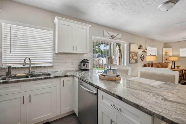 811 Patricia Pl, Lakeland, FL 33809 - kitchen featuring a sink, dishwasher, decorative backsplash, white cabinets, and a textured ceiling