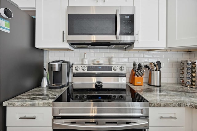 811 Patricia Pl, Lakeland, FL 33809 - kitchen featuring stainless steel appliances, white cabinets, decorative backsplash, and light stone counters