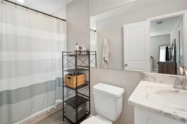 811 Patricia Pl, Lakeland, FL 33809 - full bath featuring vanity, toilet, a shower with shower curtain, and wood finished floors