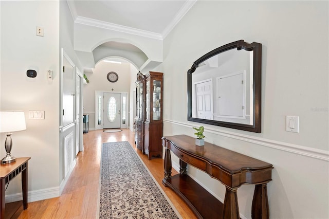 9830 Caribou Trl, Dade City, FL 33525 - hall featuring light wood finished floors, crown molding, and arched walkways