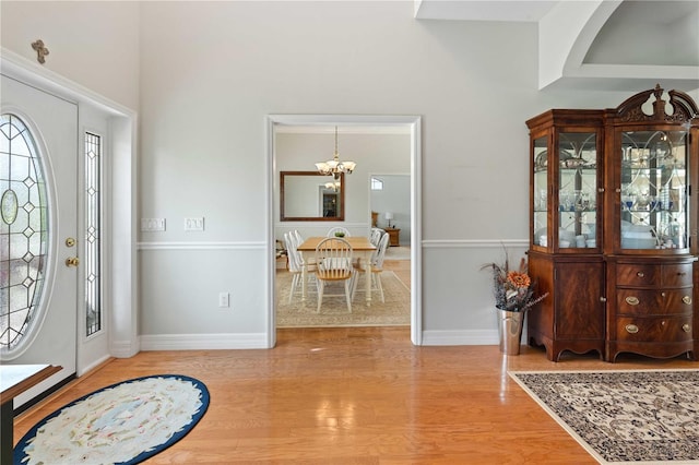 9830 Caribou Trl, Dade City, FL 33525 - foyer entrance with a chandelier, light wood finished floors, healthy amount of natural light, baseboards, and a high ceiling