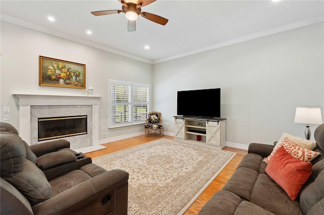9830 Caribou Trl, Dade City, FL 33525 - living room featuring a ceiling fan, light wood-style floors, crown molding, recessed lighting, and a high end fireplace