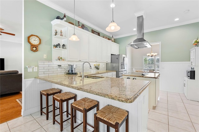 9830 Caribou Trl, Dade City, FL 33525 - kitchen with a sink, appliances with stainless steel finishes, island exhaust hood, a peninsula, and light tile patterned floors