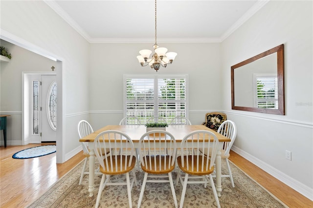 9830 Caribou Trl, Dade City, FL 33525 - dining room featuring a chandelier, wood finished floors, crown molding, and baseboards