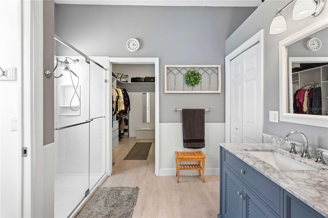 9830 Caribou Trl, Dade City, FL 33525 - full bathroom featuring vanity, a shower stall, a spacious closet, and wood finished floors