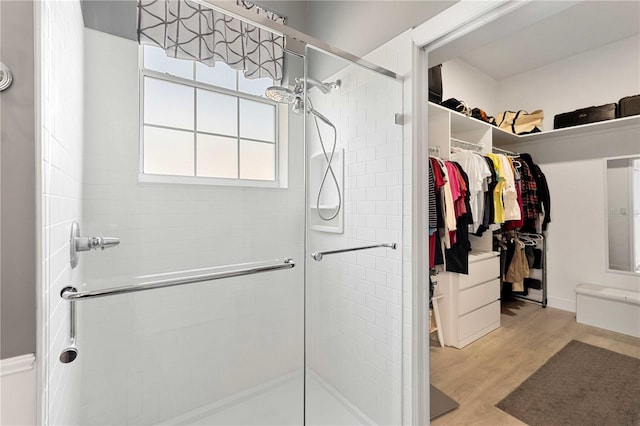 9830 Caribou Trl, Dade City, FL 33525 - bathroom featuring a shower stall, a walk in closet, and wood finished floors