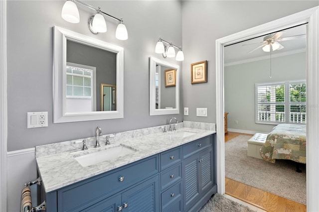 9830 Caribou Trl, Dade City, FL 33525 - ensuite bathroom with double vanity, wood finished floors, ornamental molding, baseboards, and a ceiling fan