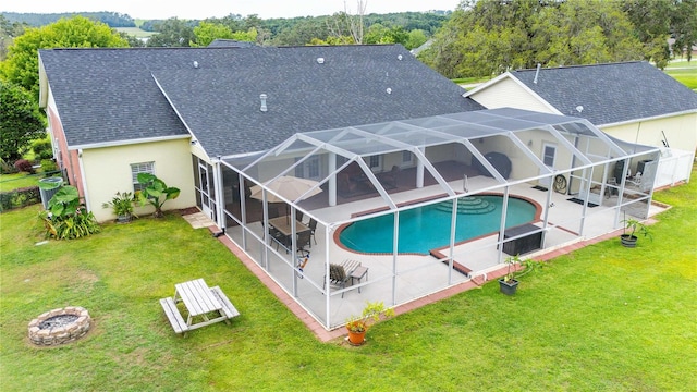 9830 Caribou Trl, Dade City, FL 33525 - back of property with a patio area, a shingled roof, an outdoor fire pit, and an outdoor pool