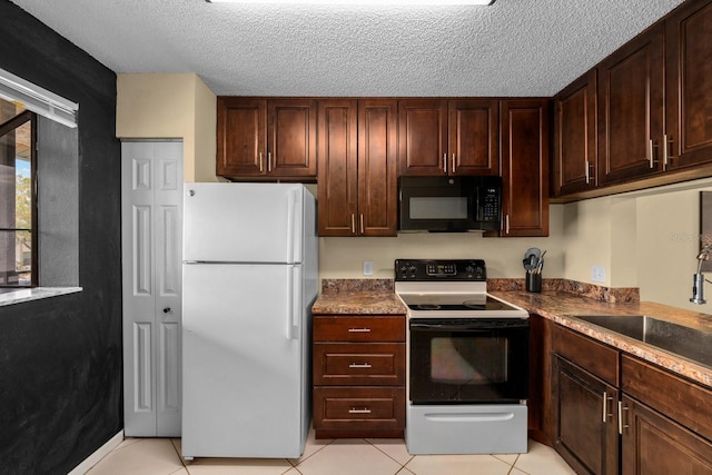 1905 Oyster Catcher Ln Unit 924, Clearwater, FL 33762 - kitchen featuring freestanding refrigerator, electric range oven, black microwave, light tile patterned floors, and a textured ceiling