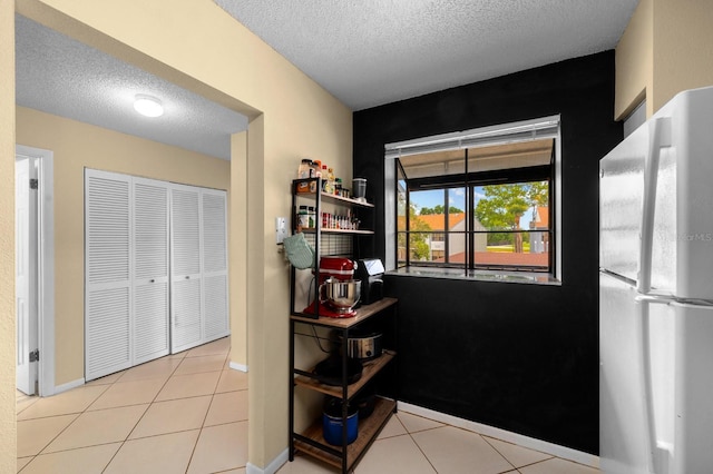 1905 Oyster Catcher Ln Unit 924, Clearwater, FL 33762 - kitchen with freestanding refrigerator, a textured ceiling, tile patterned floors, and baseboards