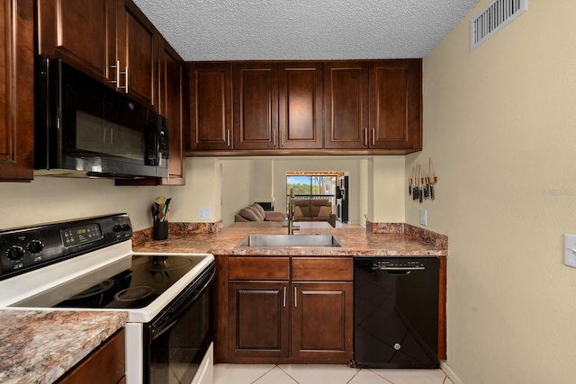 1905 Oyster Catcher Ln Unit 924, Clearwater, FL 33762 - kitchen featuring black appliances, a sink, a textured ceiling, light tile patterned floors, and dark brown cabinets