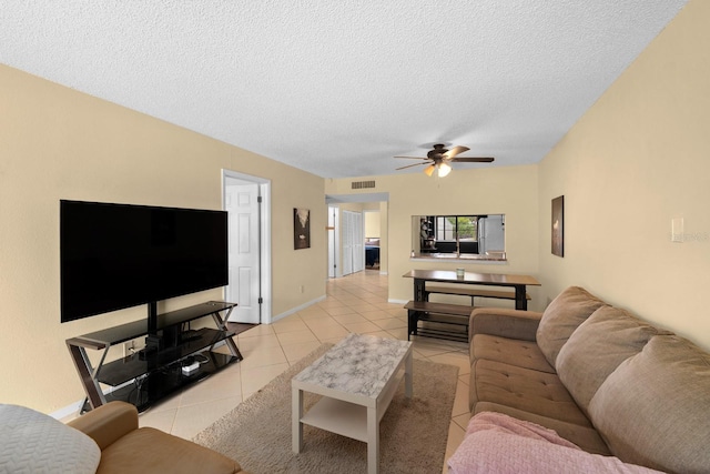 1905 Oyster Catcher Ln Unit 924, Clearwater, FL 33762 - living room featuring a textured ceiling, light tile patterned flooring, ceiling fan, and baseboards