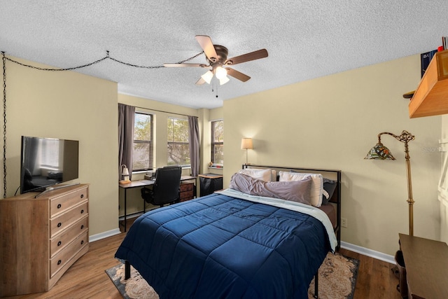 1905 Oyster Catcher Ln Unit 924, Clearwater, FL 33762 - bedroom featuring a textured ceiling, wood finished floors, baseboards, a ceiling fan, and a desk