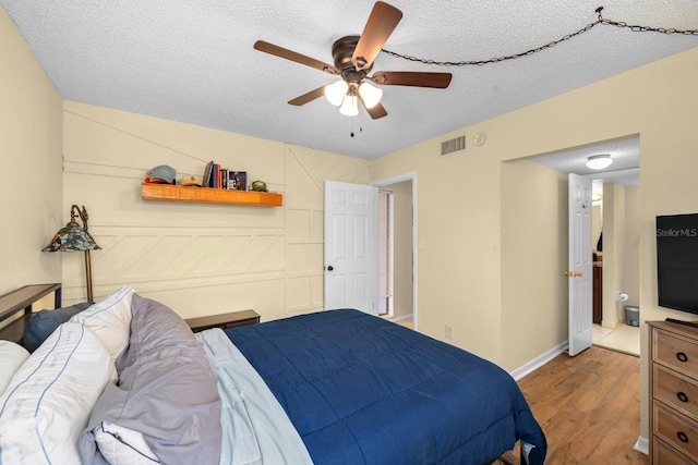 1905 Oyster Catcher Ln Unit 924, Clearwater, FL 33762 - bedroom featuring light wood-style flooring, a textured ceiling, a ceiling fan, and baseboards