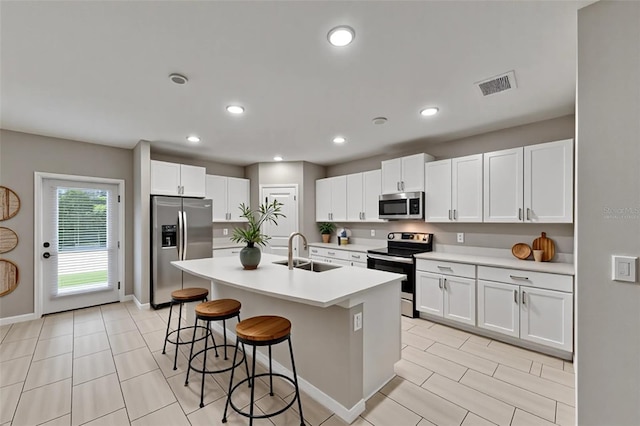 12617 Maple Bonsai Dr, Riverview, FL 33579 - kitchen featuring appliances with stainless steel finishes, a sink, light tile patterned floors, a breakfast bar area, and light countertops