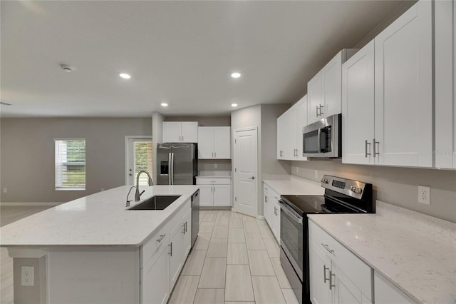 12617 Maple Bonsai Dr, Riverview, FL 33579 - kitchen featuring stainless steel appliances, a sink, white cabinetry, recessed lighting, and light stone countertops