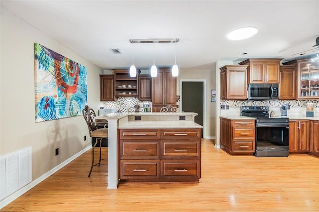 10954 96th St, Largo, FL 33773 - kitchen with appliances with stainless steel finishes, backsplash, light wood finished floors, open shelves, and pendant lighting